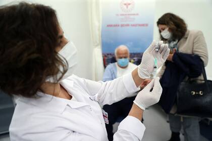 Una enfermera prepara una vacunapara un hombre que espera en el hospital de la ciudad de Ankara, en Turquía