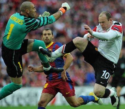 Una entrada fuerte de Rooney ante Victor Valdes (L), en un partido frente a Barcelona por la Champions League