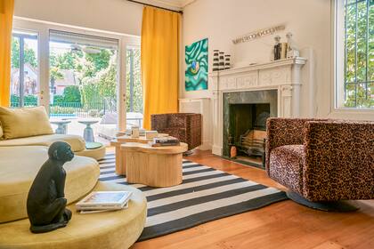 Una escultura de mono de Harturo, de fondo los sillones individuales tapizados en un género de Caro Deane.