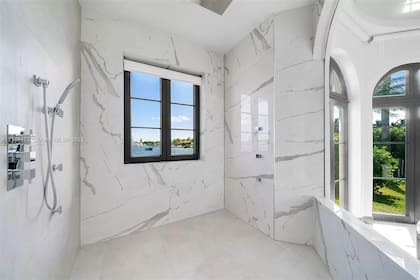 Una espectacular ducha con un pequeño muro que divide del resto del baño