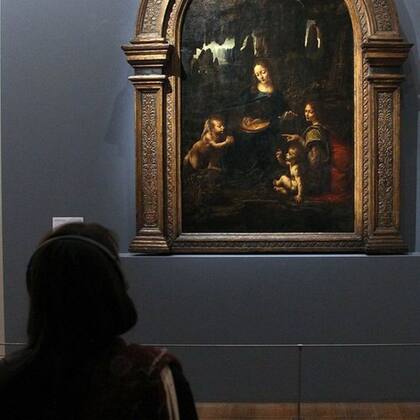 Una espectadora ante la versión de La Virgen de las Rocas del Louvre