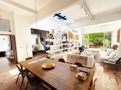 Una estantería blanca actúa como divisor semitransparente entre el área social y el acceso a la suite, además de alojar la tele, libros y cuadros.