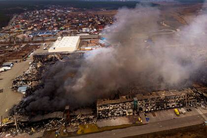 Una fábrica y una tienda arden tras ser bombardeadas en Irpin, en las afueras de Kiev, Ucrania, el domingo 6 de marzo de 2022