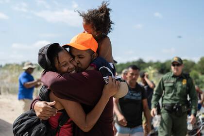 Una familia de migrantes de Venezuela se abraza después de romper una barricada de alambre de púas hacia los Estados Unidos, luego de horas de espera en la orilla de un río en el Río Grande, en Eagle Pass, Texas, el 25 de septiembre de 2023.