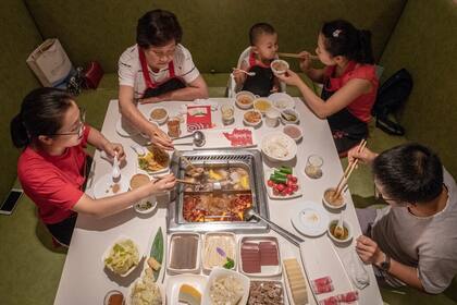 Una familia en un restaurant de Beijing. Se estima que el crecimiento poblacional en China se contraiga este siglo