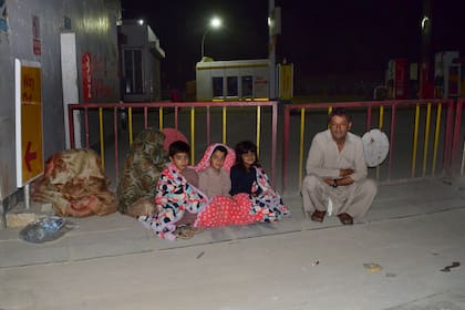 Una familia fuera de su casa tras el severo terremoto que afectó al sur de Pakistán.