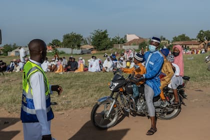 Una familia musulmana llega en moto para asistir a las oraciones del Eid al-Adha en la escuela Sayo Muhamed en medio de un brote de ébola en Bunia, Congo, el miércoles 27 de mayo de 2026. (Foto AP/Moses Sawasawa)