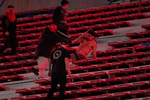 Una fanático de la Universidad de Chile (centro) es agredido por hinchas de Independiente de Argentina durante el partido por los octavos de final de la Copa Sudamericana, el miércoles 20 de agosto de 2025, en Avellaneda, Argentina. (AP Foto/Gustavo Garello)