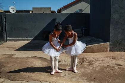 Una foto de dos estudiantes de ballet de 5 años, Philasande Ngcobo y Yamihle Gwababa, posando en julio frente a una academia de danza en Tembisa, Sudáfrica