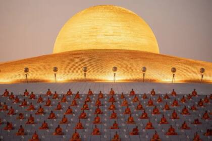 Una foto de monjes rezando bajo la vasta cúpula dorada de Wat Phra Dhammakaya durante la ceremonia anual de Makha Bucha
