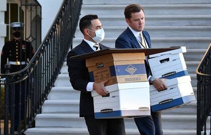 Una foto del 20 de enero de 2021 muestra a los ayudantes que llevan cajas a Marine One antes de que el presidente de los Estados Unidos, Donald Trump, y su esposa Melania Trump partieran de la Casa Blanca el último día de Trump en el cargo, en Washington, DC.