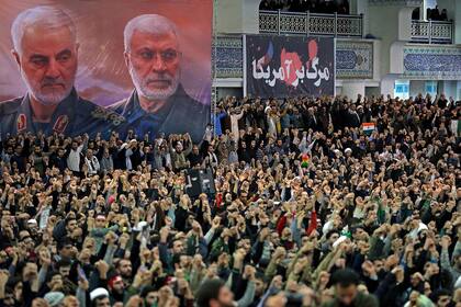 Una foto proporcionada por la oficina del Líder Supremo Ayatollah Ali Khamenei muestra a iraníes durante la oración del viernes 17 de enero de 2020, bajo los retratos del comandante iraní Qassem Soleimani, a la izquierda, y el líder de la milicia iraquí Abu Mahdi al-Muhandis, ambos asesinados en un