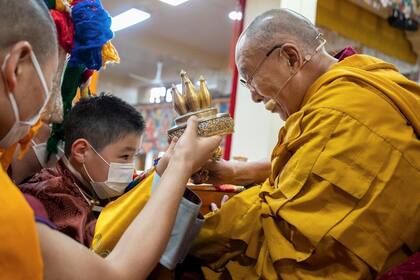 Una foto sin fecha facilitada por la oficina del Dalai Lama muestra al Dalai Lama presentando a A. Altannar, el niño mongol de ocho años que ha sido seleccionado como una de las figuras más veneradas del budismo tibetano, en una ceremonia ante fieles en marzo de 2023. 