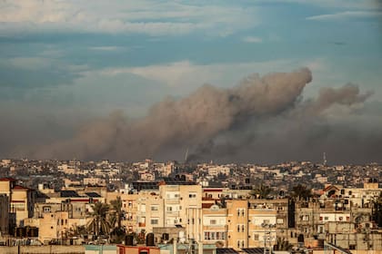 Una fotografía tomada desde Rafah, en el sur de la Franja de Gaza, muestra humo elevándose sobre los edificios en Khan Yunis durante el bombardeo israelí el 2 de febrero de 2024, mientras continúan los combates entre Israel y el grupo palestino Hamas. (Photo by Said KHATIB / AFP)