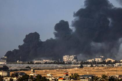 Una fotografía tomada desde Rafah muestra humo ondeando sobre Khan Yunis, en el sur de la Franja de Gaza, durante el bombardeo israelí el 22 de enero de 2024, en medio de las batallas en curso entre Israel y el grupo militante palestino Hamas.