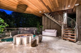 Una galería con living, piscina y chimenea exterior