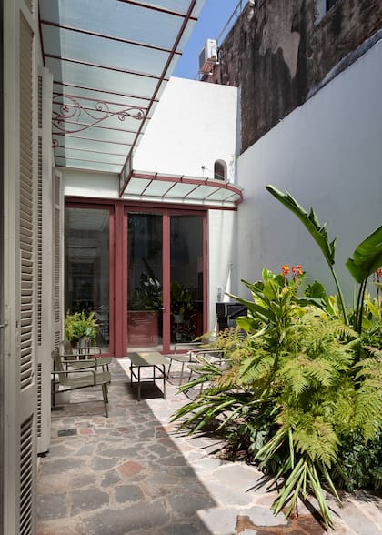 Una gran abertura de hierro integra la cocina al exterior equipado con un juego de living (Coconut lounge)