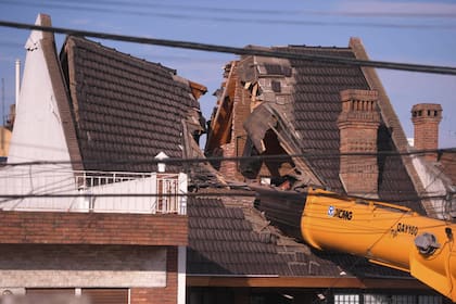Una grúa que intentaba pasar una pileta de natación por arriba de una casa, cayó sobre la vivienda y la partió al medio