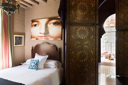 Una habitación enmarcada por una enorme puerta tallada en madera de estilo marroquí.