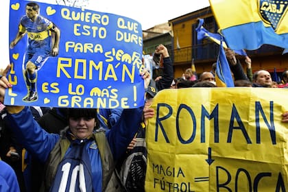 Una hincha muestra un cartel de Riquelme, en las afueras de la Bombonera