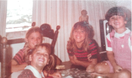 Una imagen de la infancia de Victoria Tolosa Paz, con remera negra y roja, rodeada de amigas.