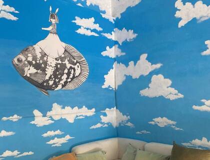 Una imagen de las paredes del cuarto de su bebé en camino, pintada con nubes y un pez volador.