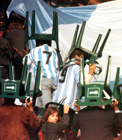 Una imagen de los hinchas argentinos tratando de cubrirse de los proyectirles que les arrojaron