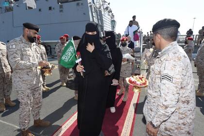 Una imagen de mano proporcionada por la Agencia de Prensa Saudí (SPA) el 22 de abril de 2023, muestra a miembros de las fuerzas armadas repartiendo chocolates y flores a ciudadanos saudíes y otros nacionales a su llegada a Jeddah, tras su rescate de Sudán.