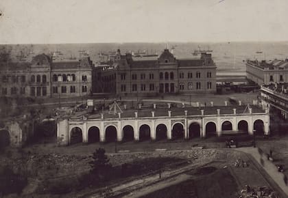 Una imagen muy antigua: el palacio de gobierno (a la izquierda) y el de Correos (a la derecha), antes de ser unificados. Delante, los arcos de la recova de Plaza de Mayo, ya estaban siendo demolidos