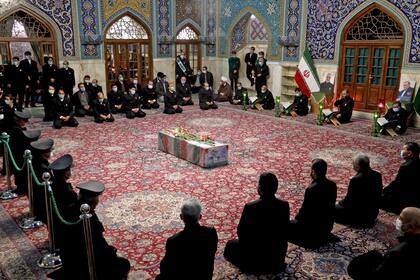Una imagen proporcionada por el Ministerio de Defensa de Irán el 29 de noviembre de 2020 muestra a los sirvientes del santuario sagrado del Imam Reza rezando alrededor del ataúd del principal científico nuclear asesinado de Irán, Mohsen Fakhrizadeh, durante su procesión fúnebre en la ciudad nororien