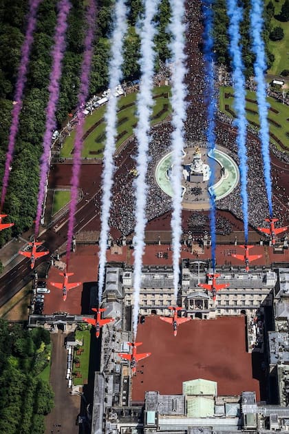 Una impactante imagen del colorido despliegue de los aviones Red Arrow sobrevolando el Palacio de Buckingham.