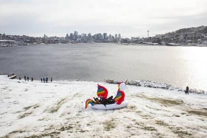 La gente disfruta de la nieve en la playa en Gas Works Park