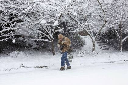 Un hombre camina para tomar fotografías de la inusual tormenta de nieve que cayó sobre Seattle