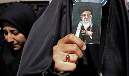 Una iraní lleva un retrato del líder supremo de Irán, el ayatolá Alí Jamenei, mientras marcha durante una manifestación a favor del hiyab en la capital, Teherán, el 23 de septiembre de 2022.