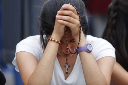 Una joven reza en las afueras de Congreso