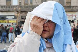 Una jubilada se frota los ojos luego de que las fuerzas de seguridad arrojaran gas pimienta