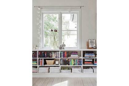 Una larga consola debajo de la ventana para generar un buen espacio de guardado sin sobrecargar visualmente el ambiente