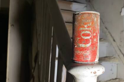 Una lata vieja de gaseosa apoyada en las escaleras del edificio