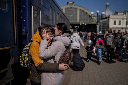 Una madre abraza a su hijo que escapó del sitio ruso en la ciudad de Mariúpol y llegó a la estación de trenes en Leópolis, el domingo 20 de marzo de 2022, en el oeste de Ucrania. (AP Foto/Bernat Armangue)