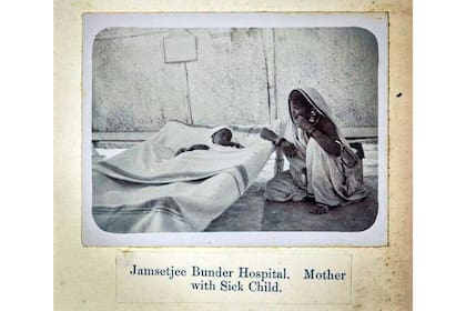 Una madre cuida a su hijo, enfermo por la plaga en Bombay