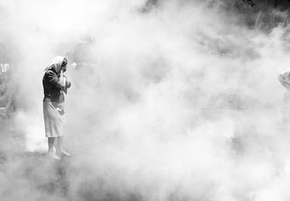 Una madre de Plaza de Mayo recibe el impacto de una granada de gas lacrimógeno el 20 de diciembre de 2001; foto de Eduardo Longoni