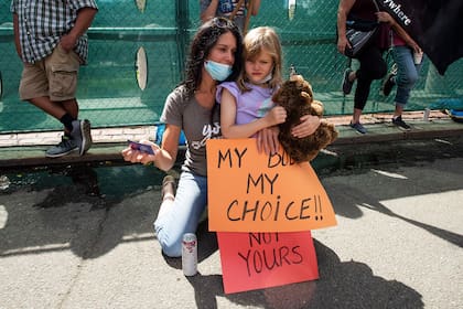 Una madre junto a su hija sostiene un cartel que dice "Mi cuerpo, mi elección" en una protesta del movimiento antivacuna en Estados Unidos