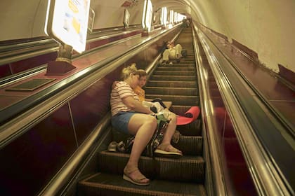 Una madre y su hija duermen en las escaleras de una estación de metro mientras se refugian durante un ataque ruso en Kiev, Ucrania, el jueves 10 de julio de 2025.