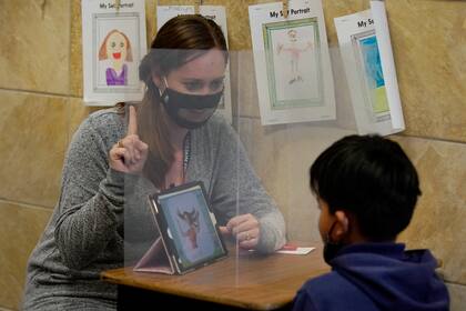 Una maestra enseña a un estudiante detrás de una mampara para protegerse de la propagación del coronavirus en Freedom Preparatory Academy, el 10 de septiembre de 2020 en Provo, Utah