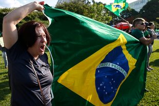 Una manifestante entona el himno nacional de Brasil, durante una protesta contra la liberación de Lula, en Brasilia