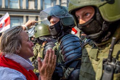 Una manifestante habla con un militar bielorruso mientras los partidarios de la oposición se manifiestan para protestar contra los disputados resultados de las elecciones presidenciales en Minsk el 30 de agosto de 2020