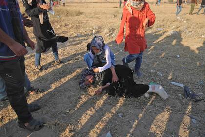 Una manifestante palestina asiste a una herida, al sur de Gaza