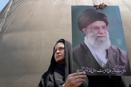 Una manifestante sostiene un cartel con la imagen del líder supremo de Irán, el ayatolá, Ali Jamenei, en una concentración contra Israel, en Teherán, Irán, el 13 de junio de 2025