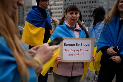 Una manifestante sostiene un cartel mientras participa en una manifestación para pedir a la Unión Europea que deje de comprar petróleo y gas ruso, frente a la sede de la UE en Bruselas, el viernes 29 de abril de 2022.