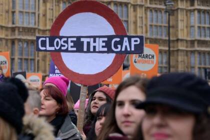 Una marcha en Londres con un cartel que dice "cierren la brecha"